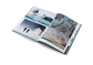 Open book displaying scenic photographs of a snowy landscape with people and a building.