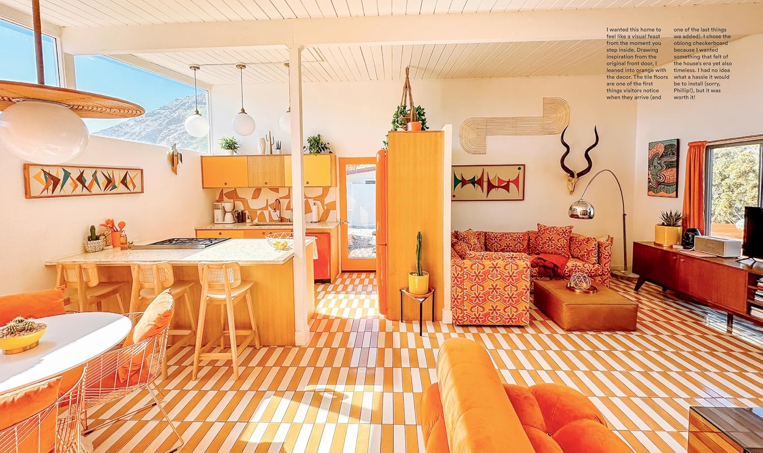 Modern living room with orange furniture and striped floor, mountain view in the background
