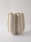 Beige ceramic vase with ribbed texture on a light gray background