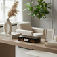 Modern living room with a coffee table, armchair, and decorative items.