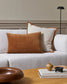 White sofa with brown and beige cushions in a living room setting.