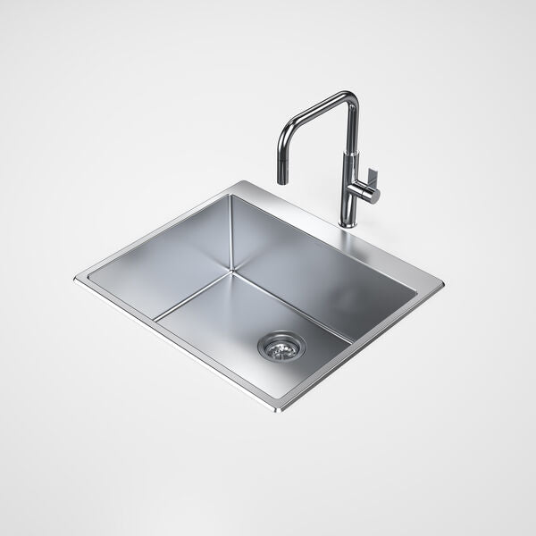 Stainless steel kitchen sink with faucet on a white background