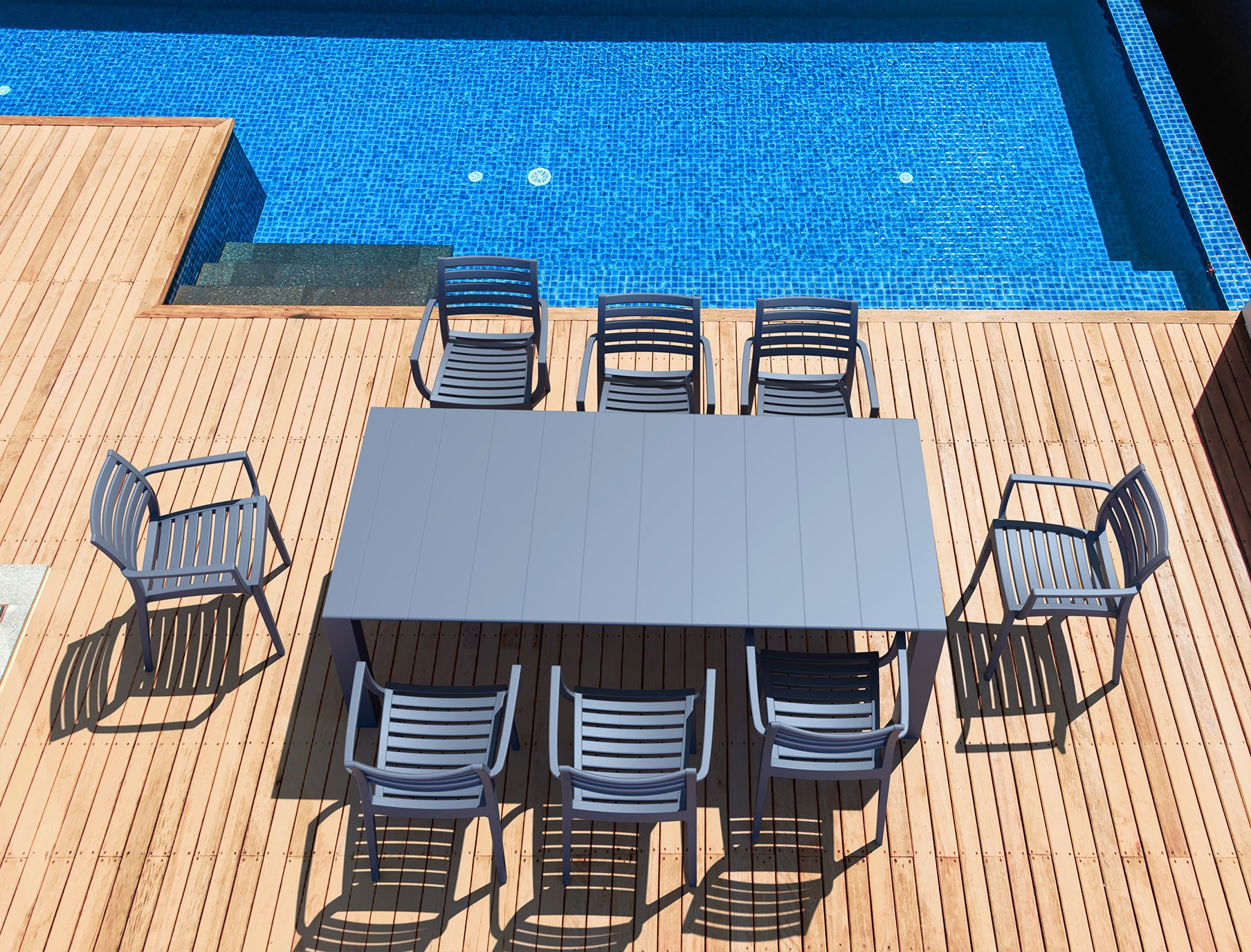 Outdoor dining table with chairs on a wooden deck by a pool