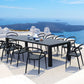 Outdoor dining set with a black table and chairs on a terrace with a scenic view of the ocean.