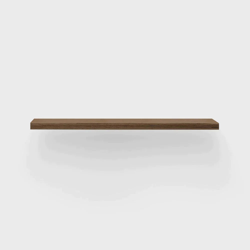 Floating walnut shelf against a white wall