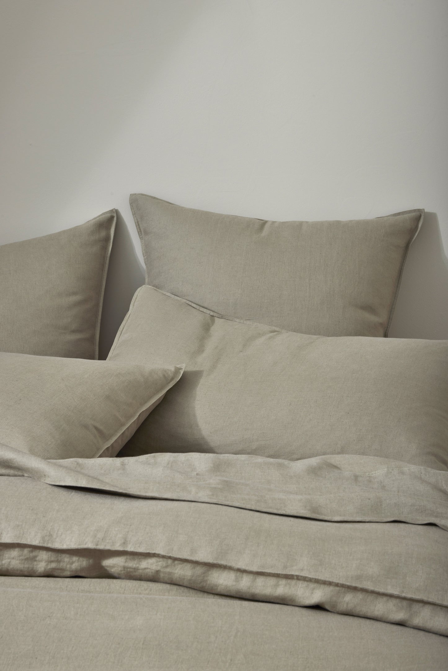 Beige bedding set on a bed with a neutral background