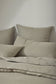 Beige bedding set on a bed with a neutral background