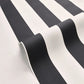 Black and white striped wallpaper shown in a close-up, rolled view to display its texture and pattern.