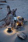Driftwood with illuminated candles on a sandy beach