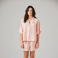 Woman wearing a pink striped linen pyjamas on a white background