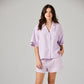 Woman wearing a lilac pajama set on a plain background