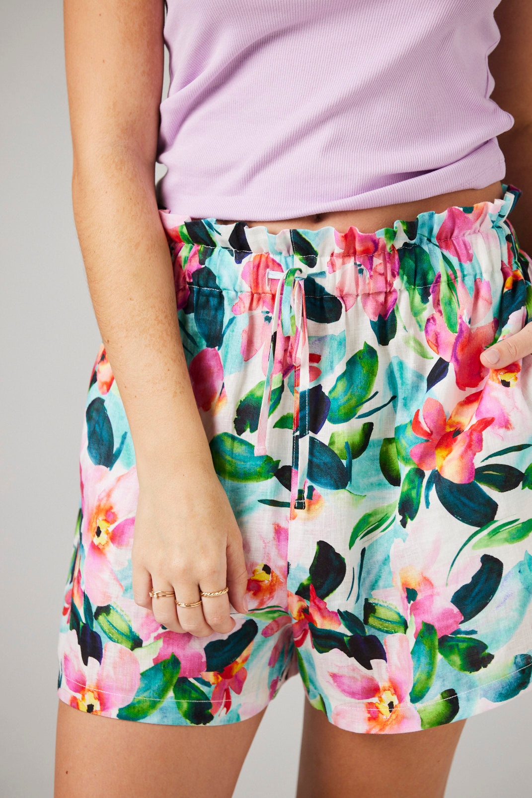 Person wearing colorful floral shorts with a plain background