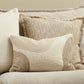 Textured pillows on a beige sofa against a neutral wall