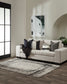 Living room with a white sofa, black and gray pillows, and a framed picture on the wall.