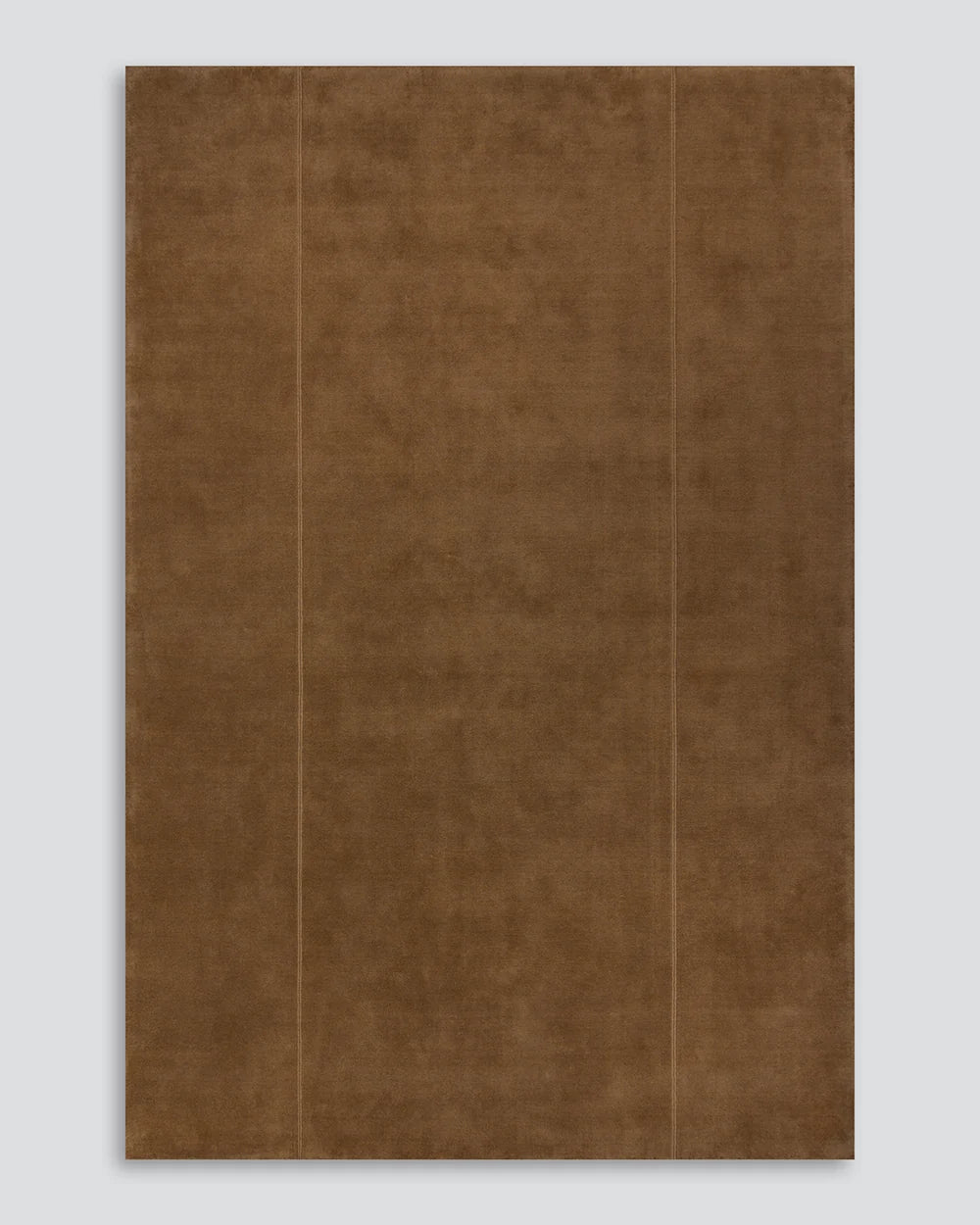 Warm hazelnut colour Bastion wool rug with a hand stitched vertical line