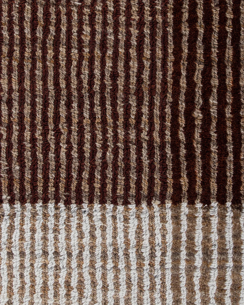 Close-up of a textured woven fabric with vertical stripes in dark brown, medium brown, tan, and off-white, showing the detailed knit or crochet texture.