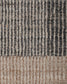 Close-up of a textured woven rug with vertical ribbed stripes in dark charcoal gray, beige, and light taupe.