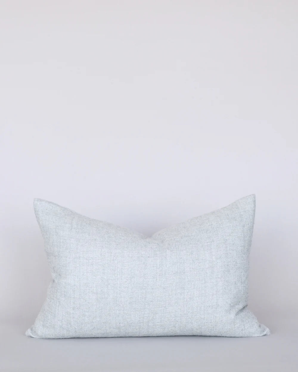 Light blue patterned pillow on a light gray background