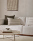 White sectional sofa with decorative pillows in a living room setting.