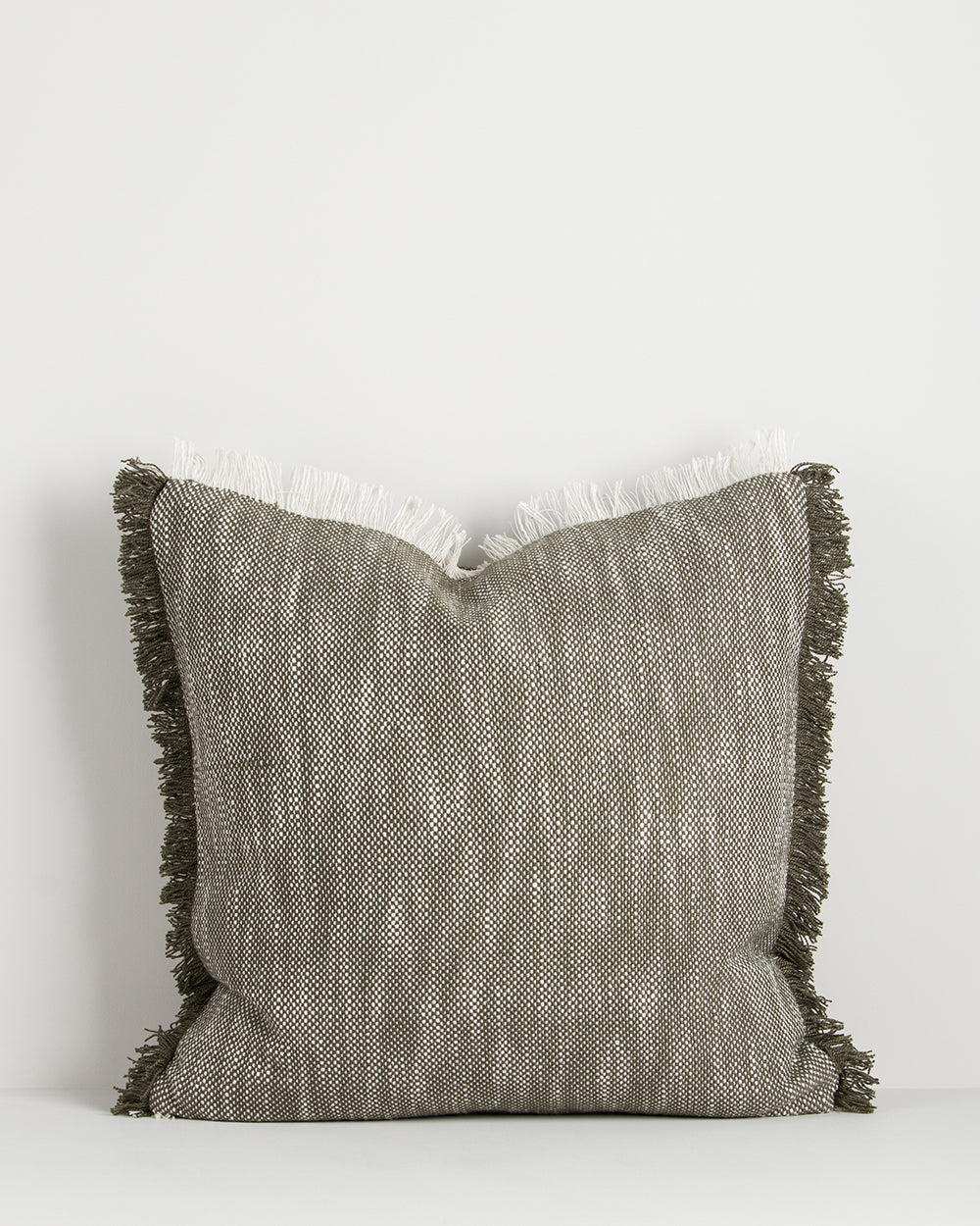 Textured pillow with fringes on a white background