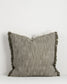 Textured pillow with fringes on a white background