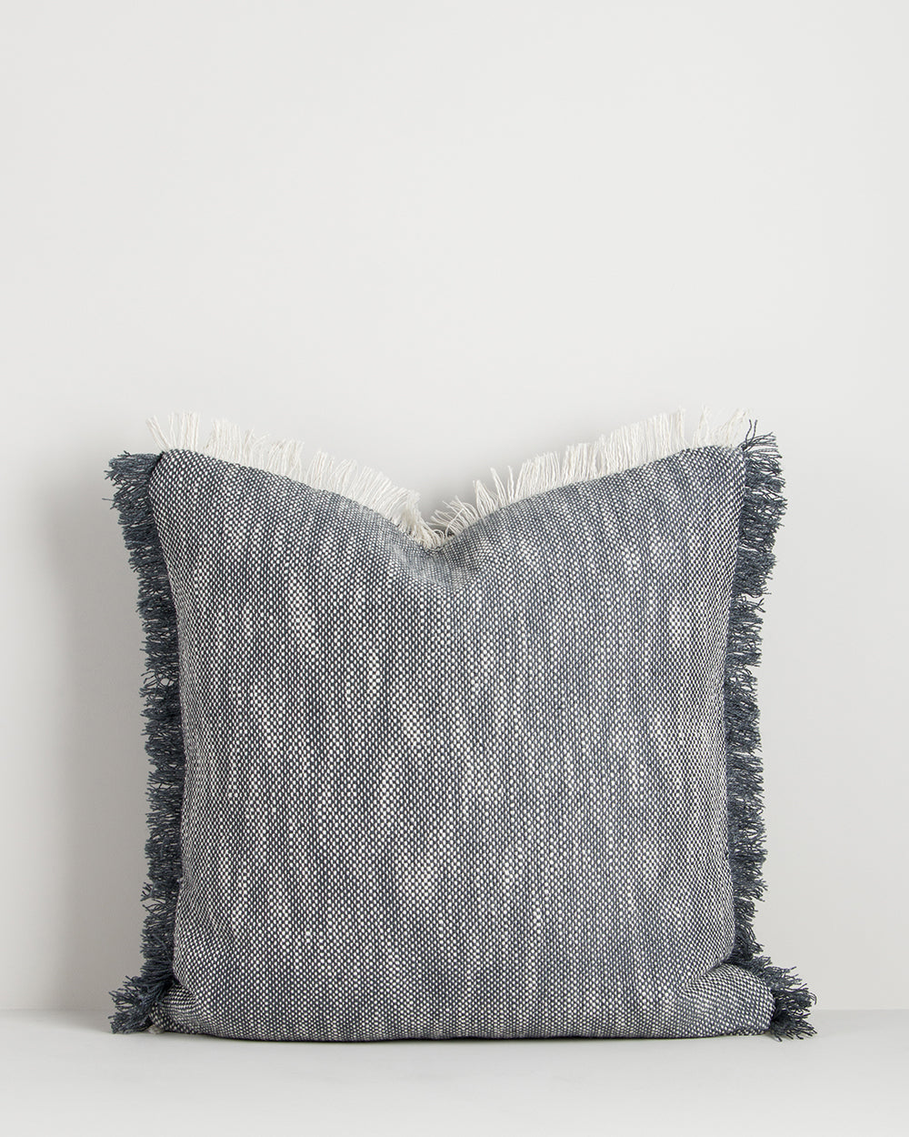 Gray textured pillow with fringes on a white background