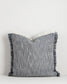 Gray textured pillow with fringes on a white background