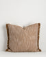 Textured pillow with fringes on a white background