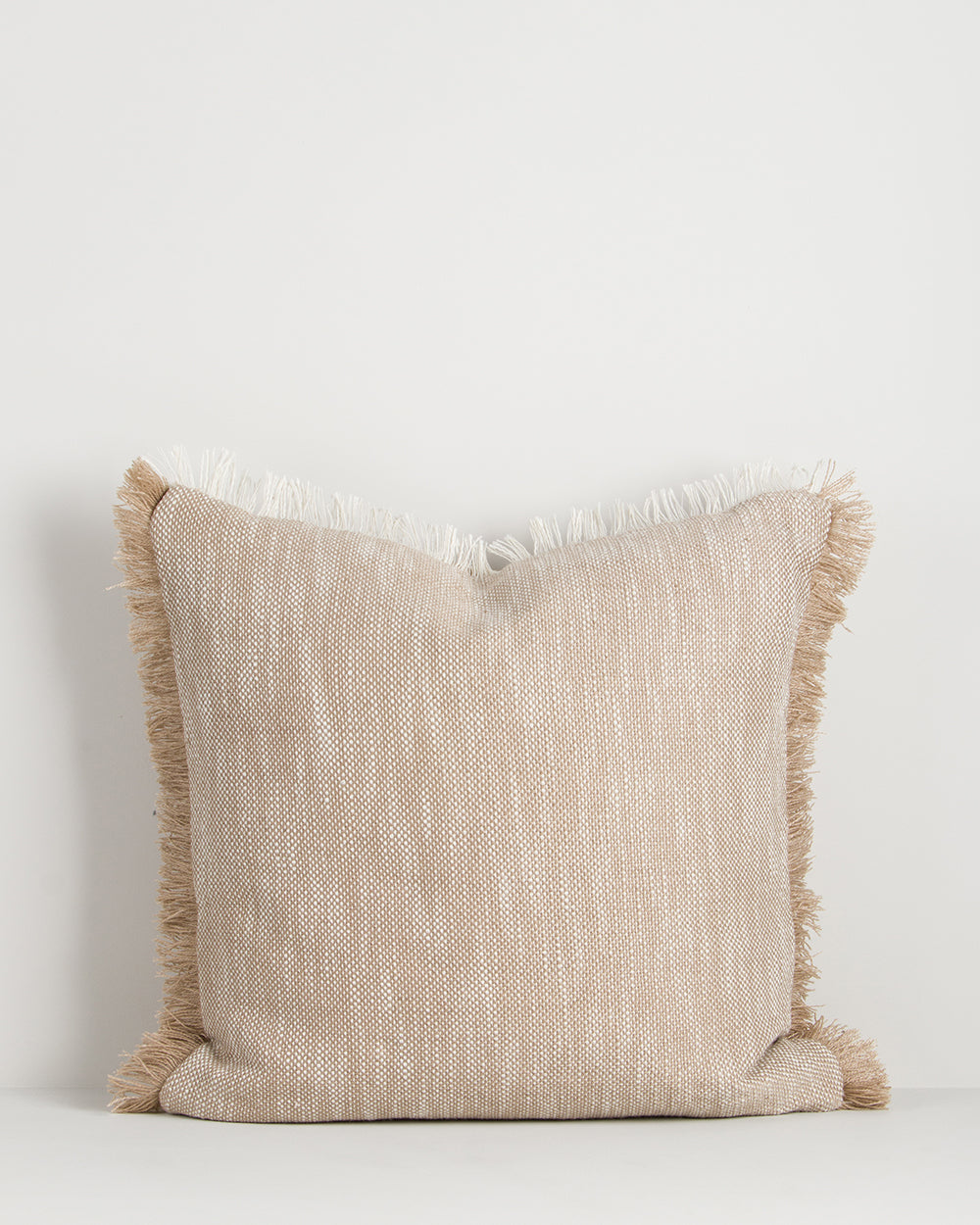 Beige pillow with fringes on a white background