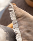 Close-up of a textured fabric with frayed edge on a wooden surface