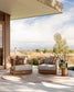 Two wooden chairs with cushions on a patio with a scenic view.