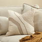 Beige sofa with textured pillows and a brown blanket on a neutral background