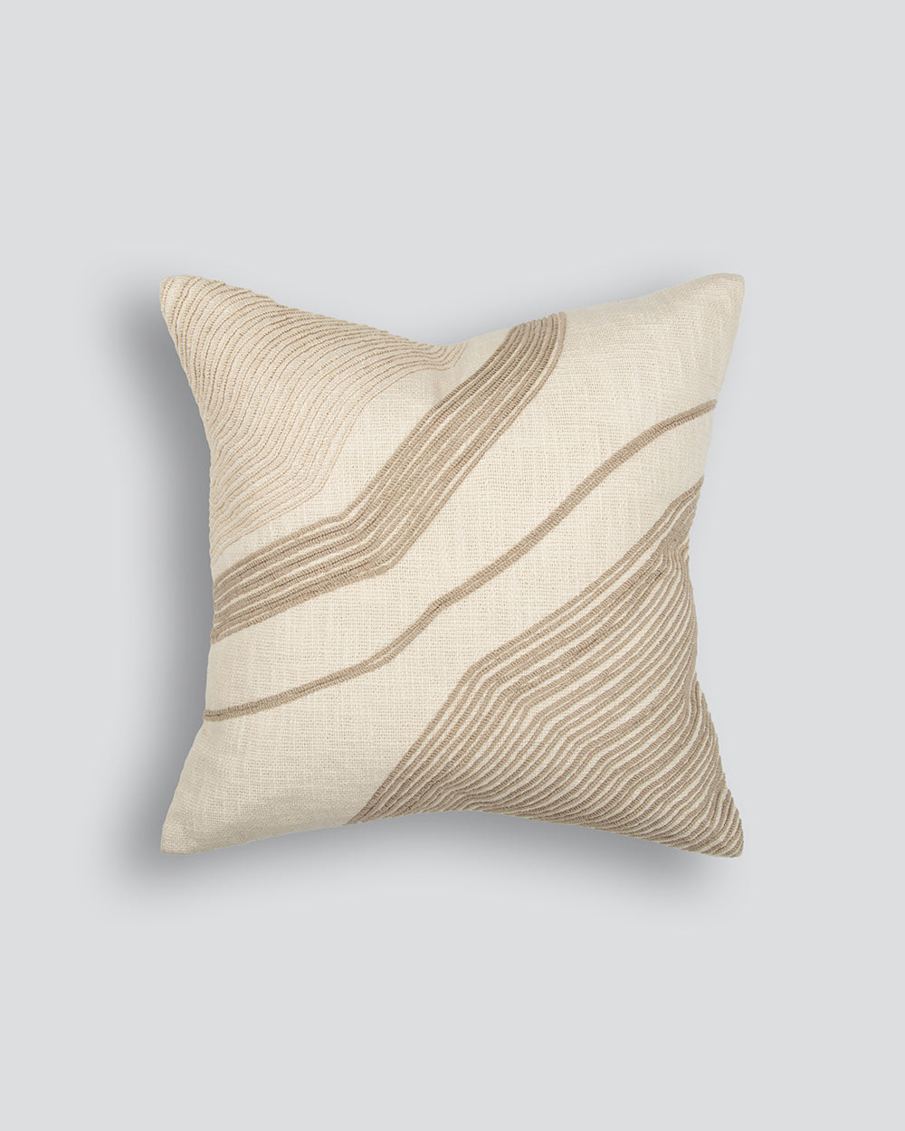 Beige pillow with wavy brown lines on a light gray background