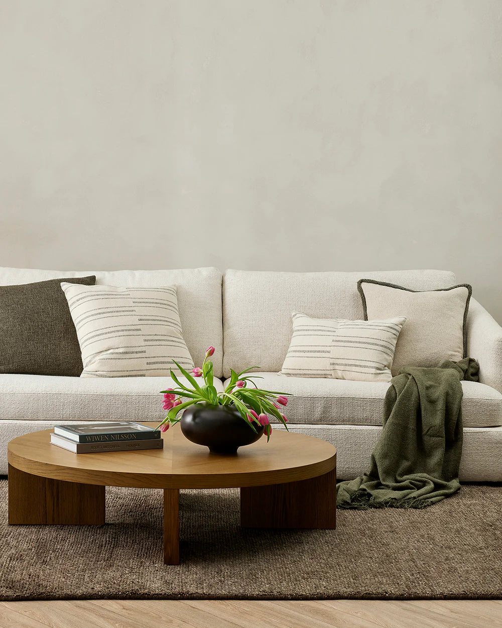 Living room with a beige sofa, wooden coffee table, and decorative items.