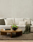 Living room with a beige sofa, wooden coffee table, and decorative items.