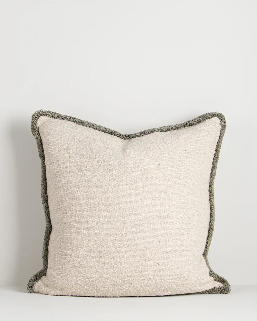 Beige pillow with dark gray border on a light gray background