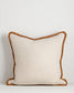 Beige pillow with brown trim on a light gray background