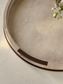 Round shagreen tray on a light gray surface with a subtle pattern