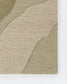 A close-up of a textured area rug with abstract organic shapes in beige and olive green, showing the looped pile texture and woven edges against a white background.
