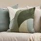 Decorative pillows in greens and blues on a sofa with a focus on color and design. Mid century style