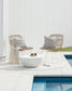Elton Wicker outdoor cushion with the morgan cushion on wicker chairs beside a pool surrounded by white tiles