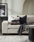 White sofa with decorative pillows and a blanket in a living room setting.
