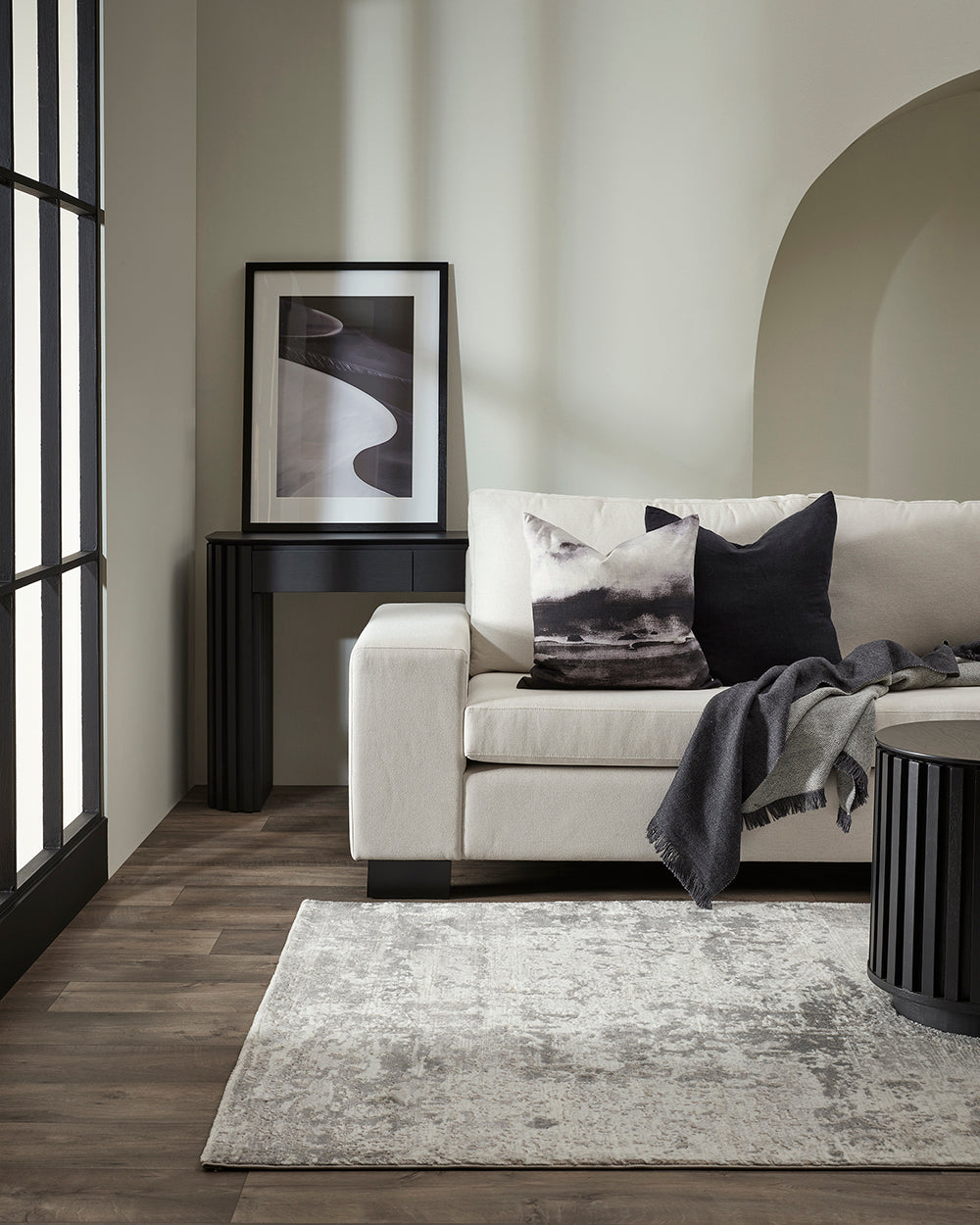 Modern living room with a white sofa, coffee table, and decorative items.