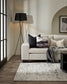 Modern living room with a white sofa, decorative pillows, and a black floor lamp.