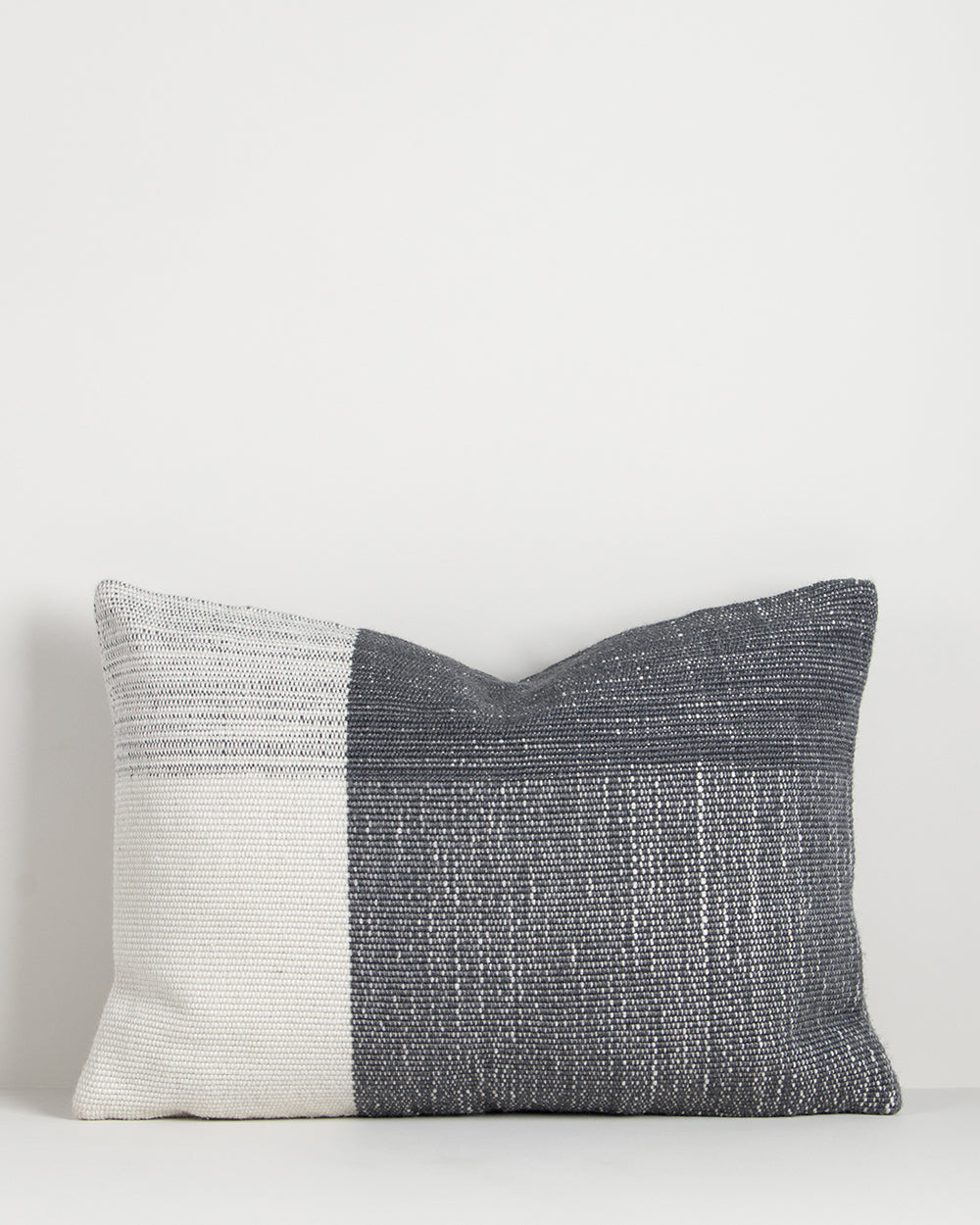 Textured pillow with two-tone design on a light gray background