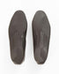 Top-down view of a pair of dark brown shoes showing the textured outsoles on a white background.