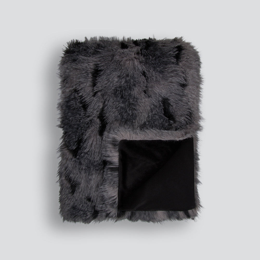 Gray fur blanket with black interior on a light gray background