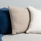 Harris textured cushion in beige alongside a blue navy cushion and white linen cushion on a grey sofa