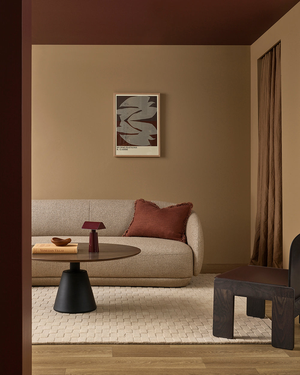 Modern living room with a beige sofa, round coffee table, and abstract art on the wall.
