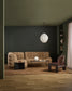 Modern living room with a beige sofa, armchair, and coffee table under a white pendant light.
